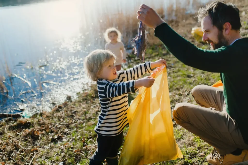 Family Collecting Rubbish Near Lake